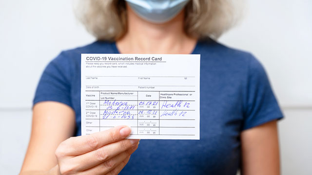Health worker holding vaccination card