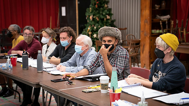 The cast of "A Christmas Carol" at a table reading of the play.