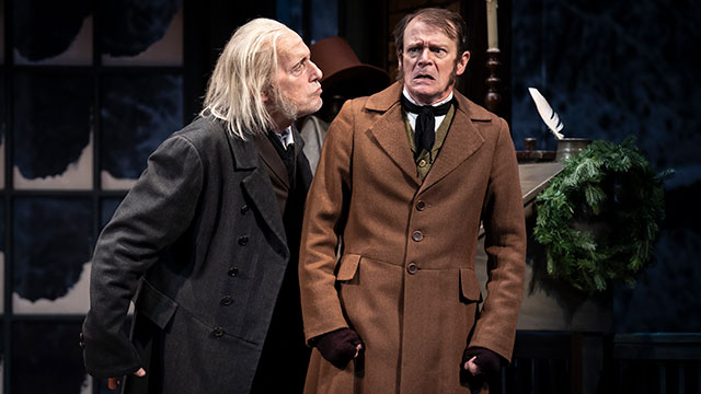 Scrooge scowling at Bob Cratchit