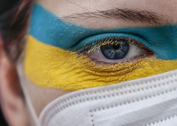 an illustration showing a face painted with the colors of the ukrainian flag