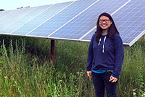 Fellowship-winning student near solar building.