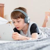 Young boy reading with headphones
