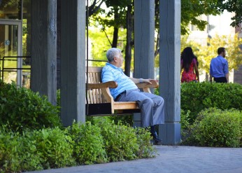Elderly man sitting on bench.