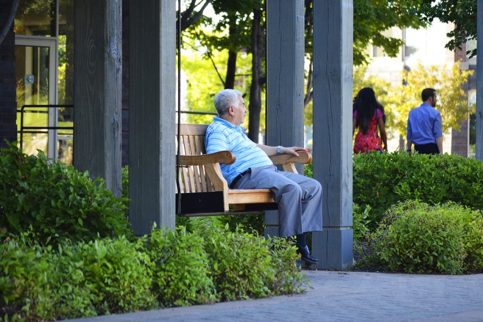 Elderly man sitting on bench.