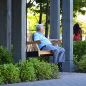 Elderly man sitting on bench.