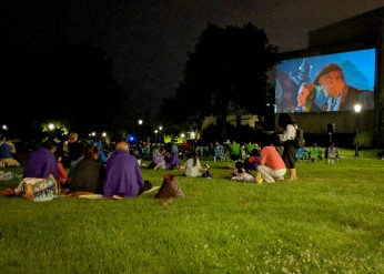 Attendees of last year's Summer Cinema series sit on the grass and watch a film 