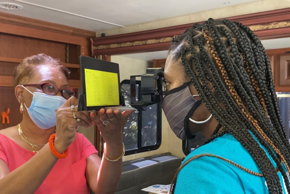 A woman administers an eye exam to a child