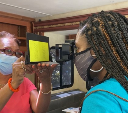 A woman administers an eye exam to a child