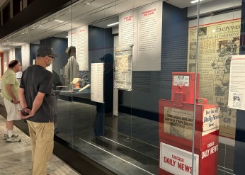 Visitors to the Mike Royko exhibit look at an honor box and printing plate