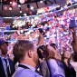 A student takes photographs during the DNC as balloons fall from the ceiling of the United Center