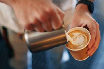 Pouring milk into a coffee 