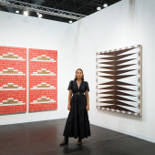 Jordan Ann Craig standing with two of her paintings