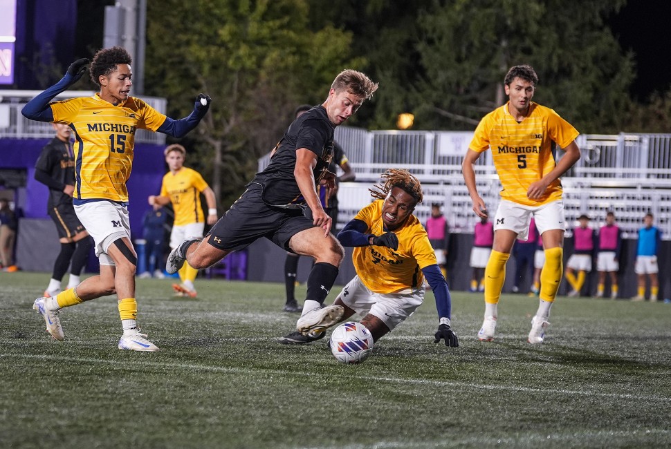 A Northwestern men's soccer player takes on Michigan players