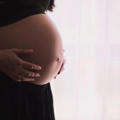 a pregnant person shown from the neck down