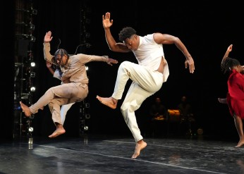 Three members of the Sankofa Danzafro company perform in a black box theater