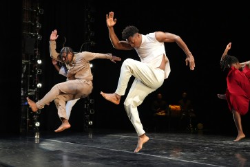 Three members of the Sankofa Danzafro company perform in a black box theater