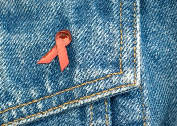 An HIV awareness ribbon on a denim background