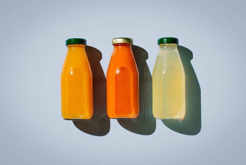 three bottles of juice on a blue background