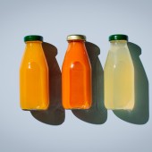 three bottles of juice on a blue background