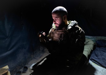 A Ukrainian soldier sits in a tent