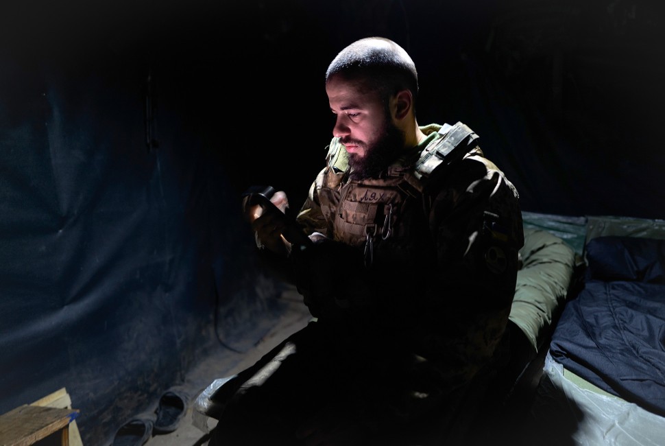 A Ukrainian soldier sits in a tent