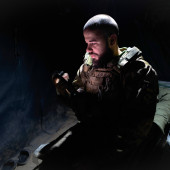 A Ukrainian soldier sits in a tent