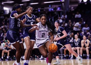 A Wildcat basketball player dribbles past three Penn State players