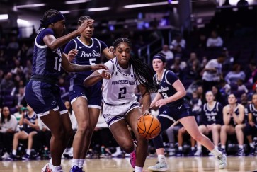 A Wildcat basketball player dribbles past three Penn State players