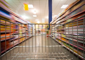 an empty shopping cart going down a grocery aisle