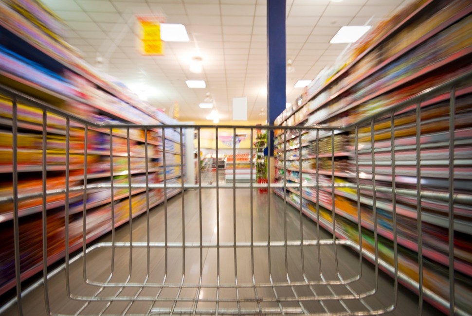 an empty shopping cart going down a grocery aisle