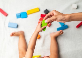 Infant playing with colored blocks