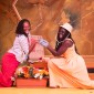 Two women clasp hands and smile during a scene in Honeypot