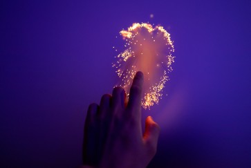 Hand touching glowing surface