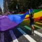 People carry a large pride flag during a parade