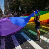 People carry a large pride flag during a parade