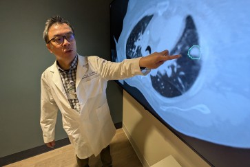 Troy Teo points to an image on a screen