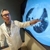 Troy Teo points to an image on a screen