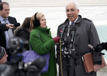 Nina Totenberg holds up a microphone while an attorney is interviewed outside the Supreme Court