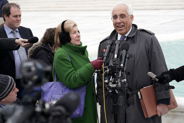 Nina Totenberg holds up a microphone while an attorney is interviewed outside the Supreme Court