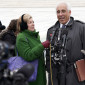 Nina Totenberg holds up a microphone while an attorney is interviewed outside the Supreme Court