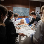 Dr. Brian Garibaldi talks to a patient with an audience of students