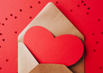 a card shaped like a red heart in an envelope 