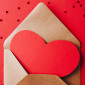 a card shaped like a red heart in an envelope 