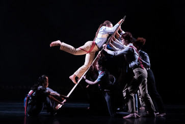 During Danceworks 2025, a dancer holds onto a board supported by other dancers