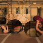 Three dancers onstage at the Driehaus Museum, two hold circular mirrors reflecting the space