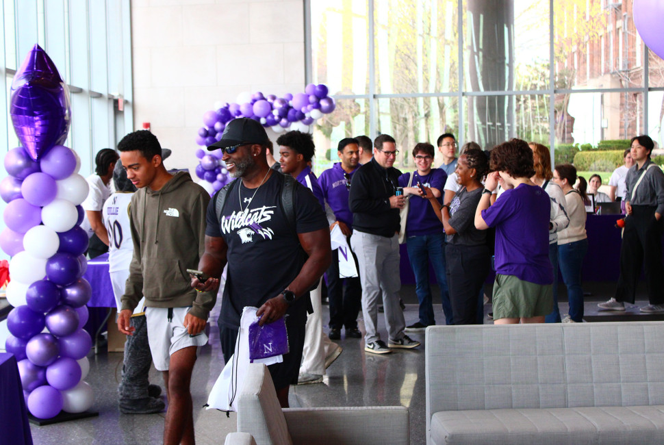 Admitted students and their guests in Segal Visitors Center with purple and white balloons in the background