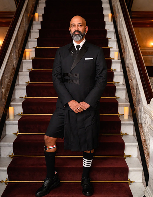 Brendan Fernandes poses on a flight of stairs