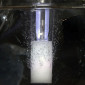 A glass tube bubbles against a black background