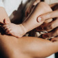 A closeup on the leg of an infant in a man's arms