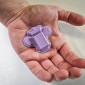 The purple wearable polygraph device rests in the palm of a hand